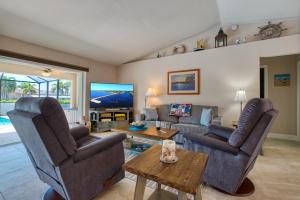 un salon avec deux chaises et une télévision dans l'établissement VILLA BOATERS DREAM - 3 BEDS 2 BATHS - 8 GUESTS - GULF ACCESS & POOL/SPA - INCL.10% OFF BOAT RENTAL, à Cape Coral