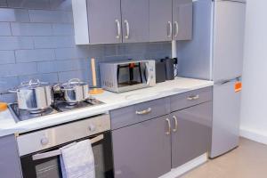 a kitchen with stainless steel appliances and a microwave at Beautiful 3 bed house next to Westfield London in London