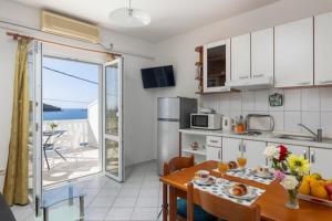 una cucina e una sala da pranzo con tavolo e vista sull'oceano di House Rasica a Molunat