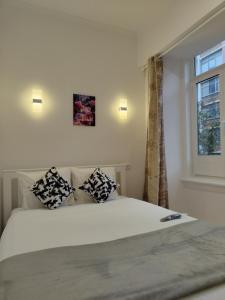 a bedroom with a white bed with pillows and a window at Apartamento Sebastian in Lisbon