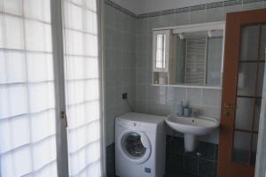 y baño con lavadora y lavamanos. en Charming and Quiet Assago House, en Assago