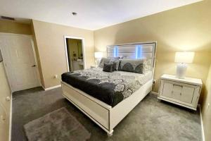 a bedroom with a large bed and a night stand at Luxury Miami 2br Townhouse Near Stadium !! in Miami Gardens