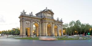 a building with a clock tower in a park at Hospes Puerta de Alcalá, a Member of Design Hotels in Madrid