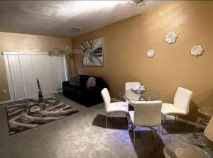 a living room with a glass table and white chairs at Luxury Miami 2br Townhouse Near Stadium !! in Miami Gardens