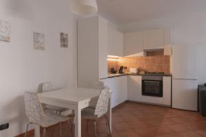 a white kitchen with a white table and chairs at Charming and Quiet Assago House in Assago