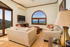 a living room with two couches and a television at Casa Cinco Sinsontes in Playa Hermosa