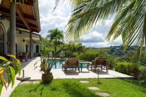 un patio con mesa, sillas y piscina en Casa Cinco Sinsontes en Playa Hermosa