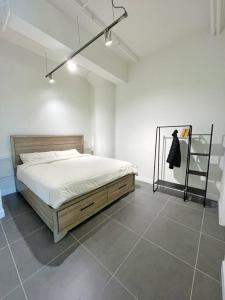 a bedroom with a bed in a white room at Modern Loft in DTLA - Rooftop Pool & Free Parking! in Los Angeles