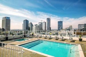 a swimming pool on top of a building with a city skyline at Modern Loft in DTLA - Rooftop Pool & Free Parking! in Los Angeles