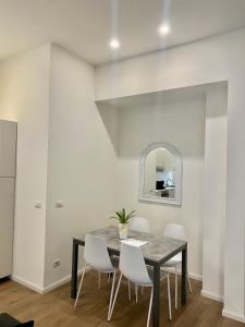une salle à manger avec une table noire et des chaises blanches dans l'établissement Apartment in Brera Milan, à Milan