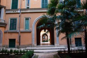 un ingresso a un edificio con una palma di Home Rent Mancini a Roma