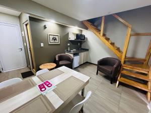 Ingá Apart & Suites في بويرتو إجوازو: غرفة معيشة مع طاولة وكراسي ودرج