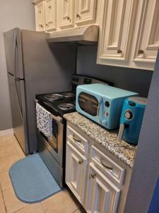 uma pequena cozinha com um micro-ondas e um fogão em Blue Shark *E3* @ Midtown Cozy 1BR King Suite em Houston