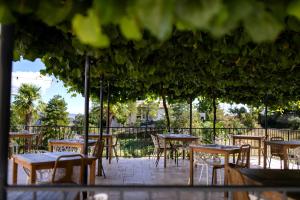 un grupo de mesas y sillas en un patio en Domaine de la Pinède en Aubenas