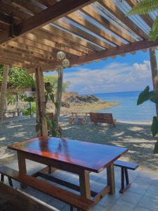 a picnic table on the beach with a view of the ocean at Inay’s Beachfront House in San Juan