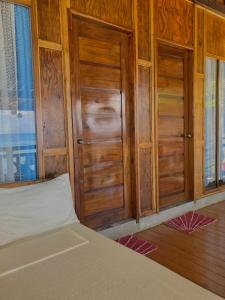 a bedroom with wooden cabinets and a bed in it at Inay’s Beachfront House in San Juan