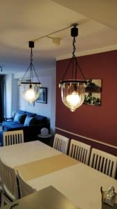 a dining room with two chandeliers and a table and chairs at 3 bedrooms appartement with wifi at Valencia 3 km away from the beach in Valencia