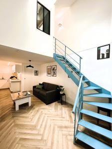 a living room with a staircase and a couch at La Maison Hugo in Montreuil
