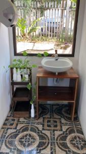 La salle de bains est pourvue d'un lavabo et d'une fenêtre. dans l'établissement Bikini Beach, à El Remate
