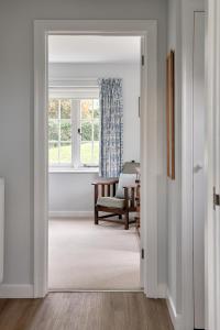 an open door into a living room with a window at Garden flat near Goodwood with stunning views in Petersfield