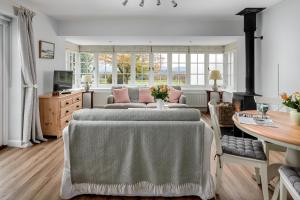 a living room with a table and a couch at Garden flat near Goodwood with stunning views in Petersfield