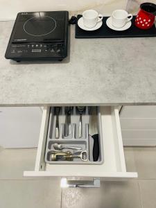 Luxury Centar في أراندجيلوفاك: طاولة مطبخ مع درج مفتوح مع اواني