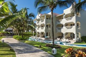 an exterior view of the resort with palm trees at El Dorado Casitas Royale Catamarán, Cenote & More Inclusive in Puerto Morelos