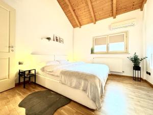 a white bedroom with a large bed and a window at The Loft in Timişoara