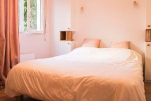 Schlafzimmer mit einem Bett mit weißer Bettwäsche und einem Fenster in der Unterkunft Cozy 40 m in Old Puteaux in Puteaux