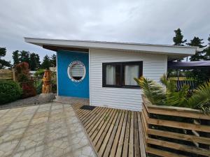 a small white house with a blue wall at Cabaña Bienvenidos a Bordo in Algarrobo