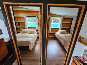 Habitación con 2 camas y 2 espejos. en Cabaña Bienvenidos a Bordo, en Algarrobo