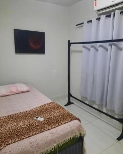 a bedroom with a bed and a shower curtain at Segundo andar in Uberlândia