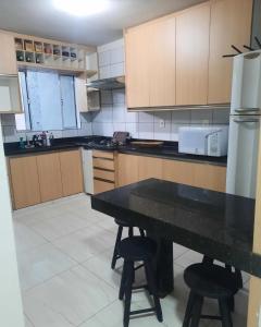 a kitchen with a table and two stools in it at Segundo andar in Uberlândia