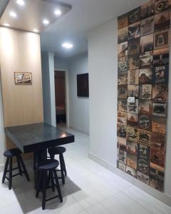 a black table and stools in a room with a wall at Segundo andar in Uberlândia