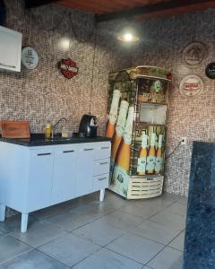 a kitchen with a counter with a sink and a refrigerator at Segundo andar in Uberlândia