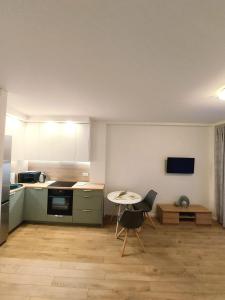 a kitchen with a table and a small table and chairs at 2 kambarių butas ramioje vietoje in Palanga