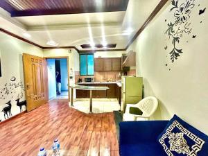 a living room with a blue couch and a kitchen at Family Apartment No 2 ISB F-11 in Islamabad