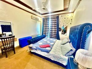 a bedroom with a blue bed and a table at Family Apartment No 2 ISB F-11 in Islamabad