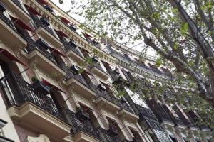 a building with a balcony with people on it at Hospes Puerta de Alcalá, a Member of Design Hotels in Madrid