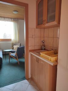 a kitchen with a sink and a chair in a room at Privat Mária in Liptovský Ján