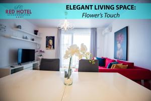 a living room with a table with a vase of flowers on it at Red Hotel Riviera Suite&Lake in Cluj-Napoca