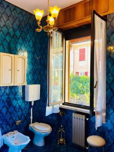 a blue bathroom with a toilet and a window at Premier étage in Varazze