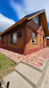 uma pequena casa de tijolos com um pátio de tijolos em frente em La casita suereña em Esquel