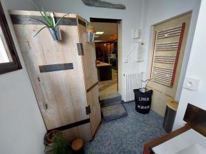 un couloir doté d'une porte en bois et d'une plante en pot. dans l'établissement Loft Partagé Agréable et spacieux, à Aire-sur-lʼAdour