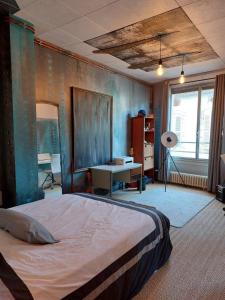 - une chambre avec un lit et un bureau dans l'établissement Loft Partagé Agréable et spacieux, à Aire-sur-lʼAdour