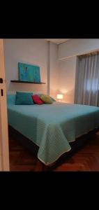 1 dormitorio con 1 cama grande con sábanas y almohadas azules en Cómodo para 4 personas Recoleta en Buenos Aires