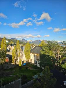 une maison avec une cour plantée d'arbres et de montagnes dans l'établissement El Condor Fueguino II, à Ushuaia