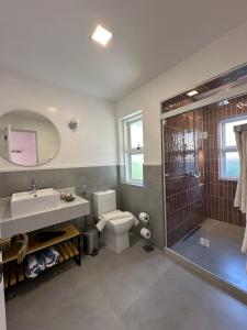 a bathroom with a toilet and a sink and a shower at Pousada Corsario Buzios in Búzios