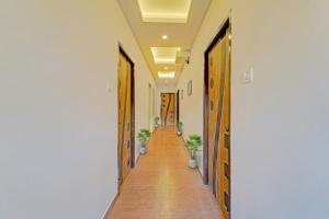 um corredor com portas e vasos de plantas num corredor em OYO Townhouse 1090 G SILVER HOTELS NEAR US BIOMETRIC em Chennai