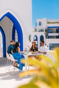 Cloud 7 Residences Ayla Aqaba في العقبة: مجموعة من الناس يجلسون على طاولة في مطعم